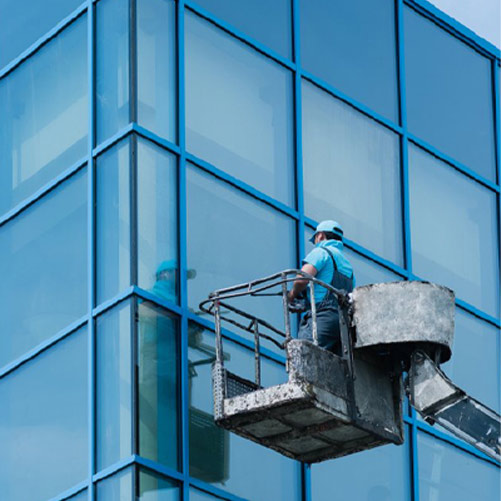 Technician cleaning glass from an elevated platform